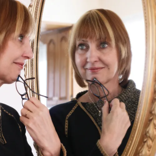 Woman looking in mirror at herself.