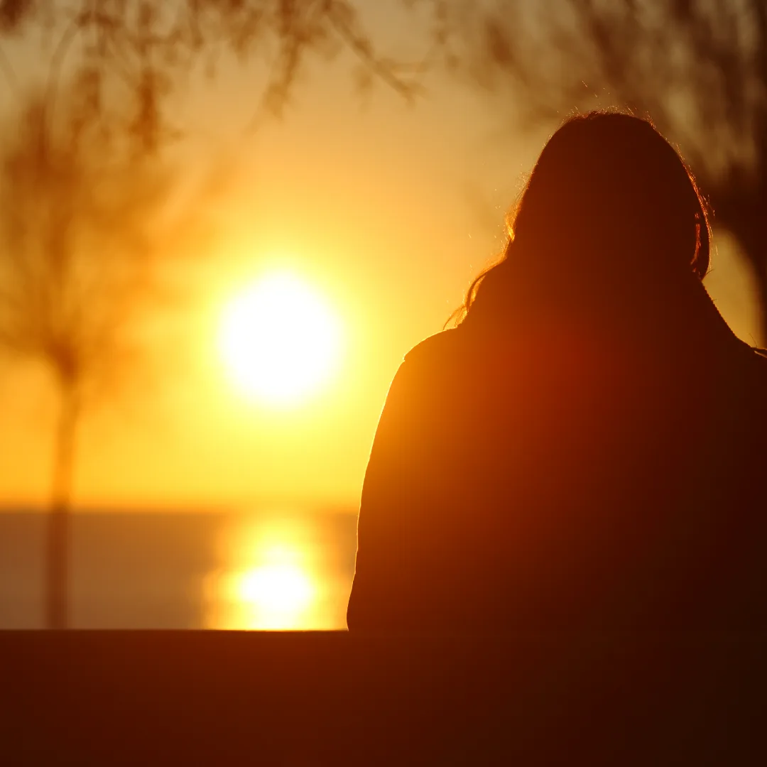 Person sitting and watching the sunset.