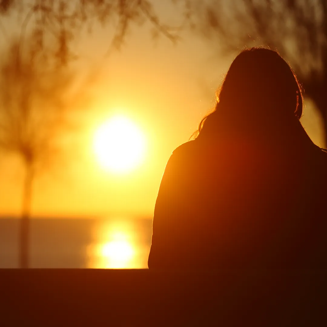 Person sitting and watching the sunset.