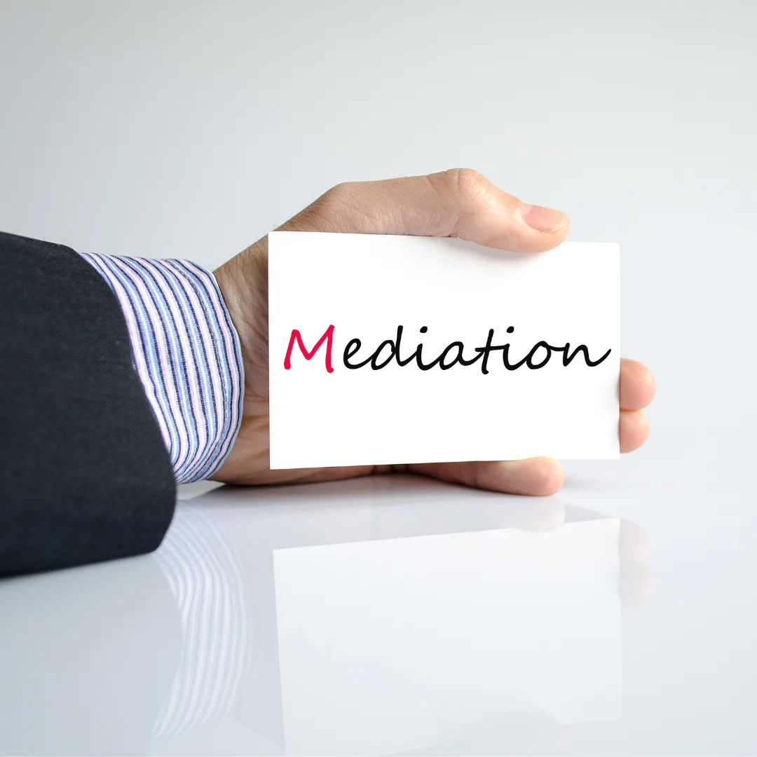 Man's hand holding mediation card.