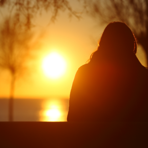 Person sitting and watching the sunset.