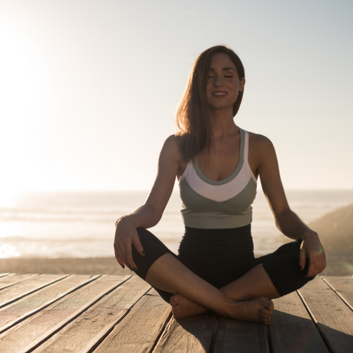 Woman sitting cross legged in yoga pose.
